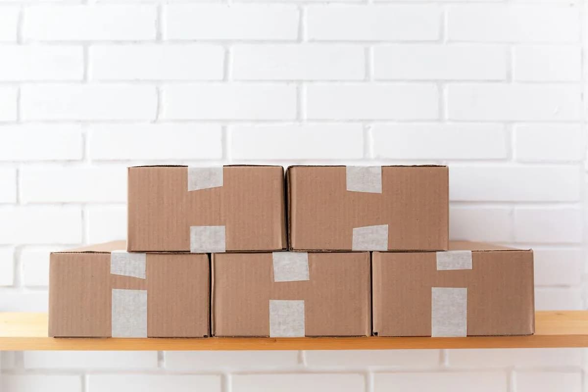 Plain cardboard boxes stacked on a wooden shelf