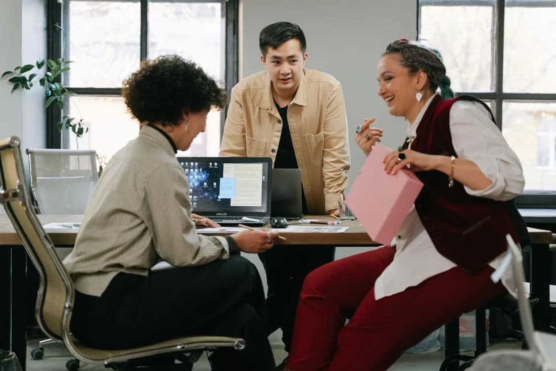 Colleagues laughing together at a desk